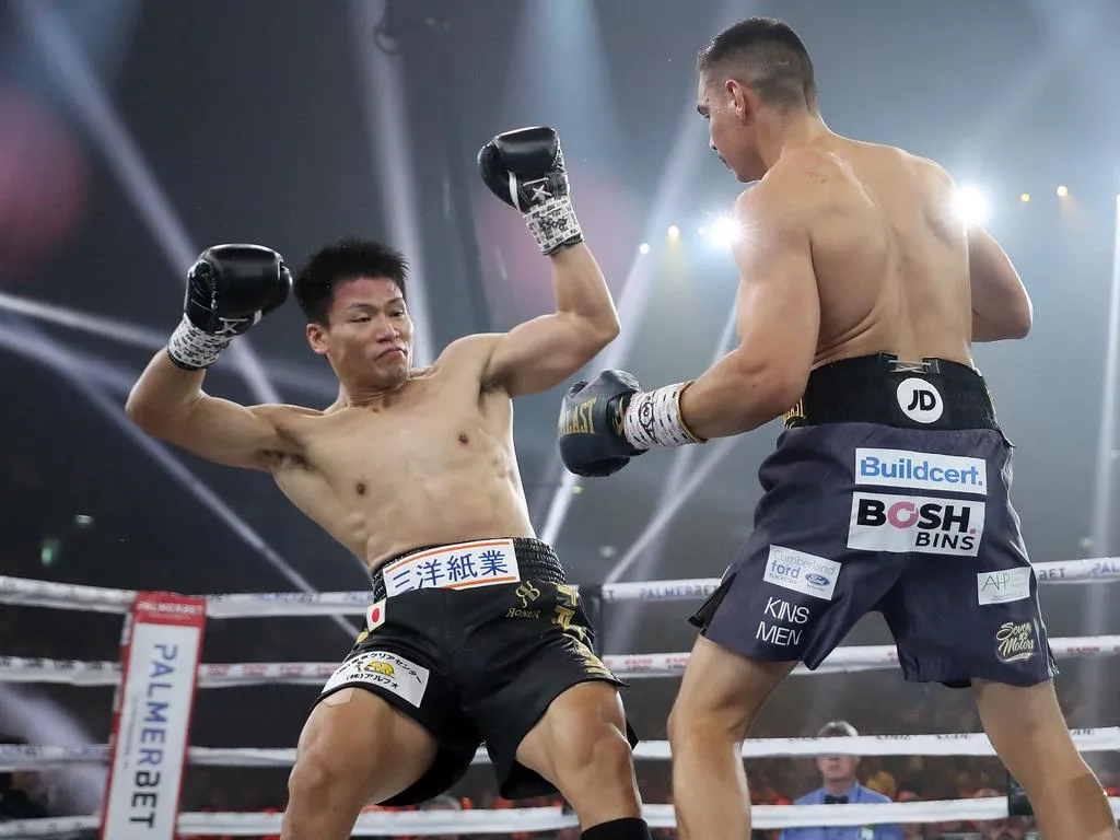 Two professional boxers exchanging punches under bright ring lights