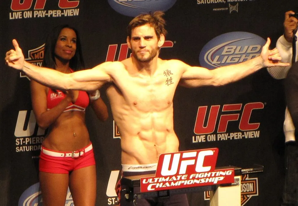 MMA fighter posing with arms outstretched on the scales at a weigh-in