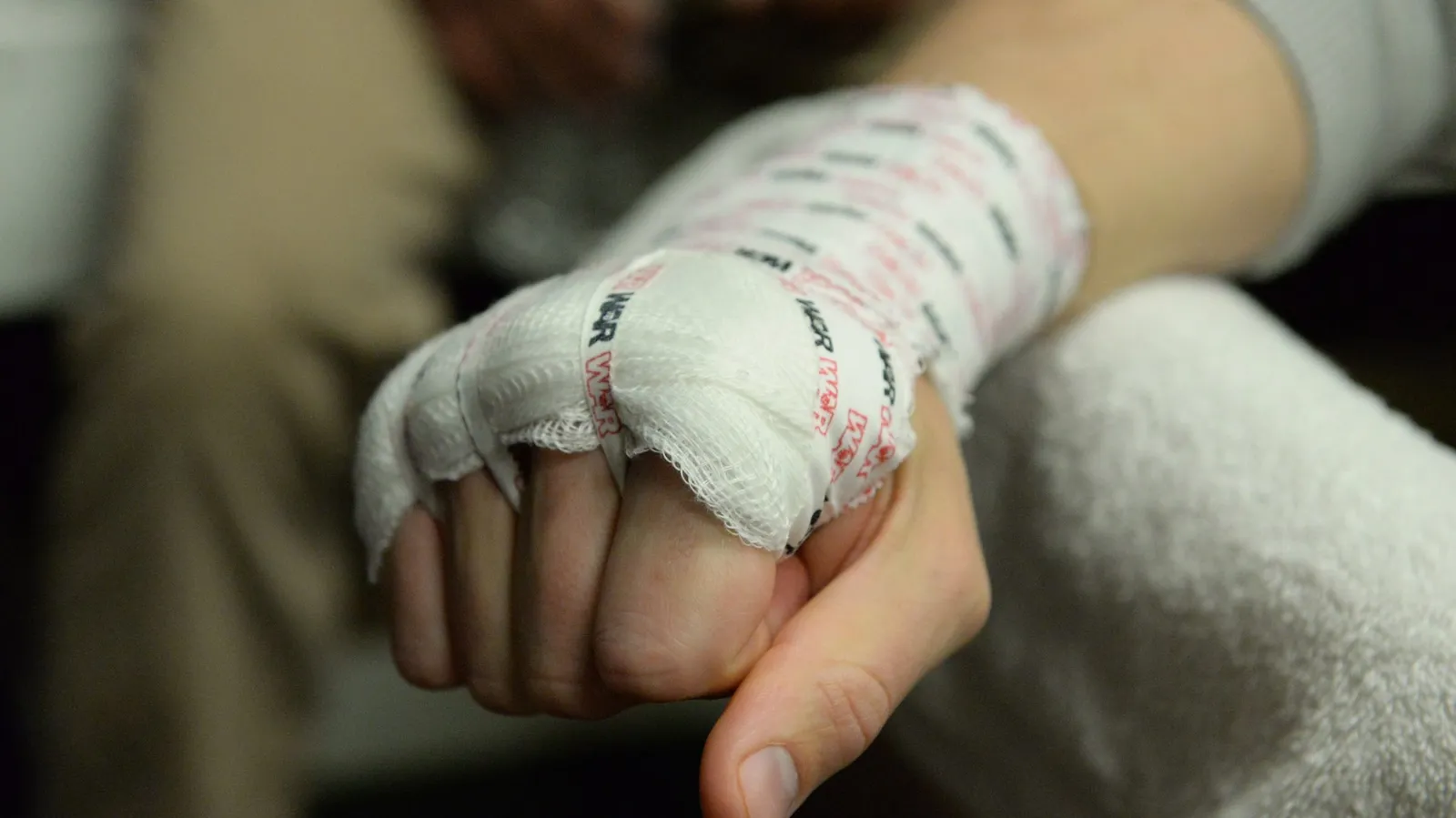 Close-up of a bandaged hand clenched into a fist