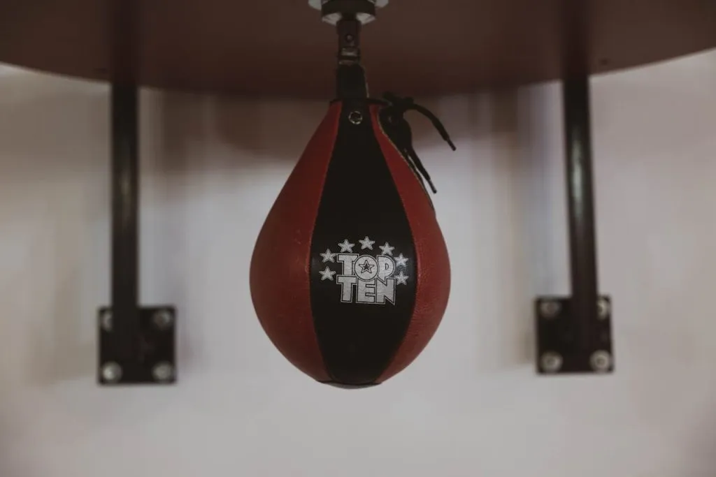 Red and black speed bag mounted on a wall in a gym