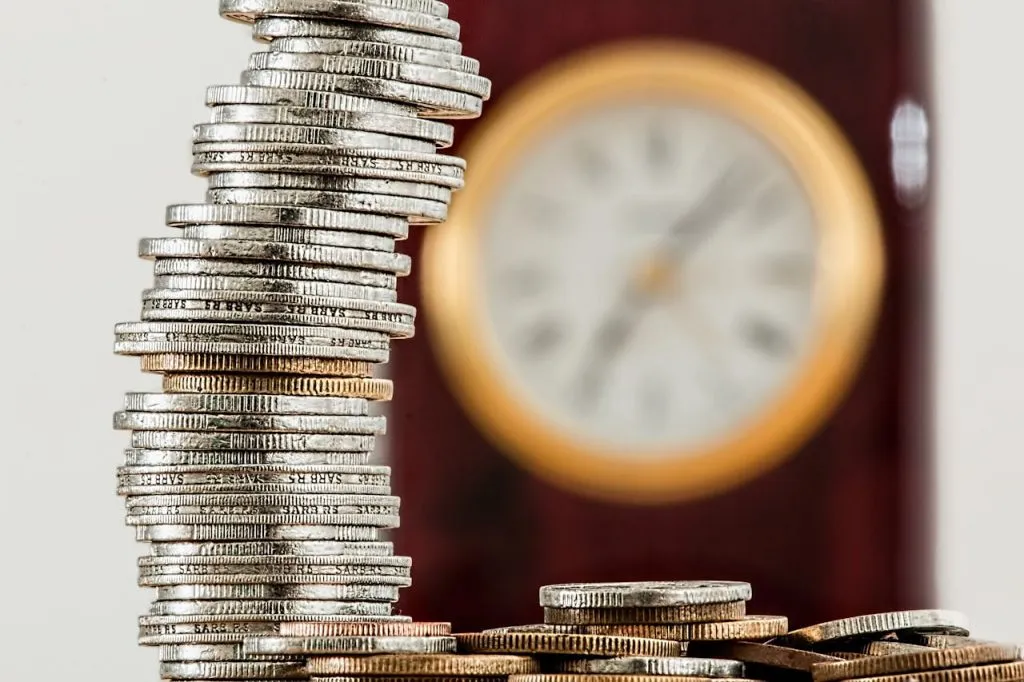 Tall stack of coins in front of a clock