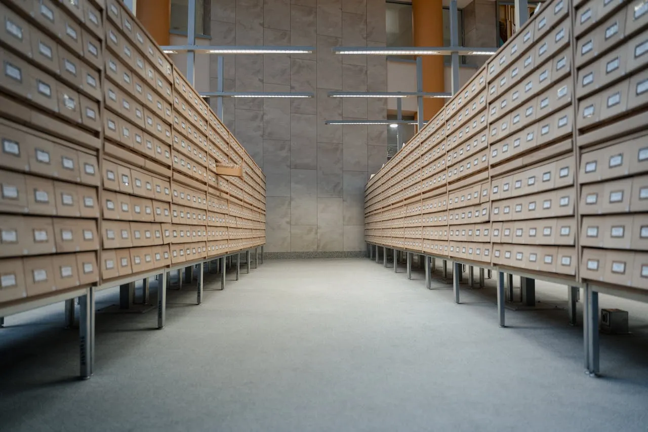 Empty archive room lined with rows of wooden filing drawers