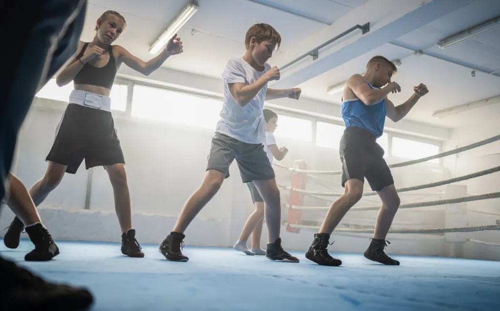Boxing class shadowboxing together in a sunlit gym