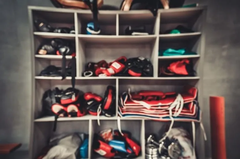 Shelves in a Muay Thai gym stacked with gloves, shin guards and training gear