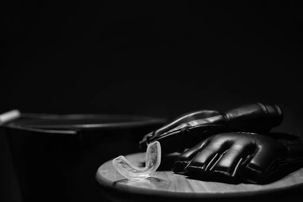 MMA gloves and a mouthguard resting on a wooden stool