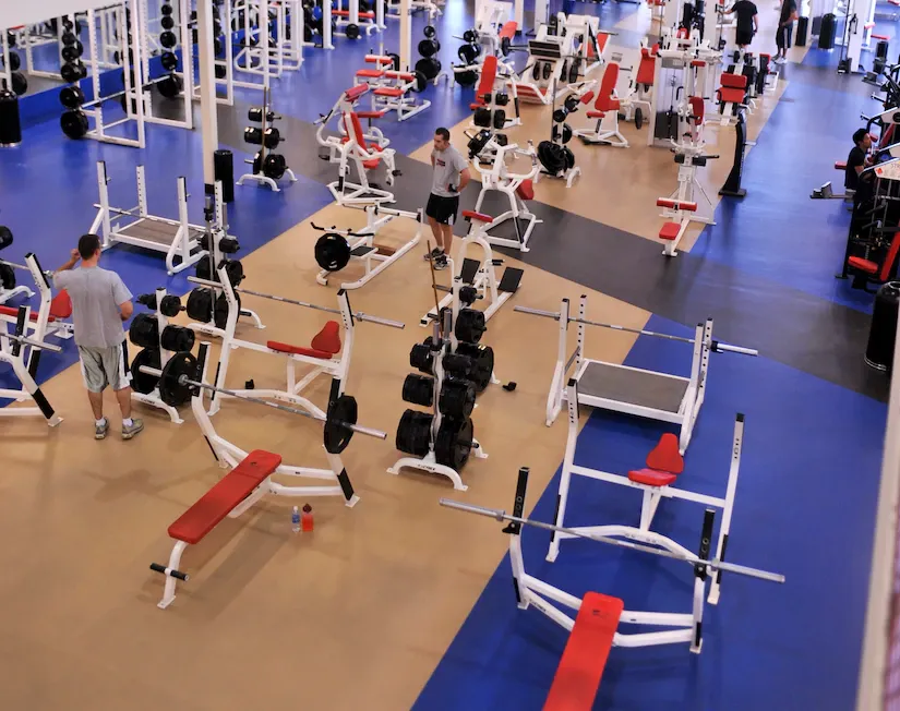 Overhead view of a large weights gym with rows of benches and racks
