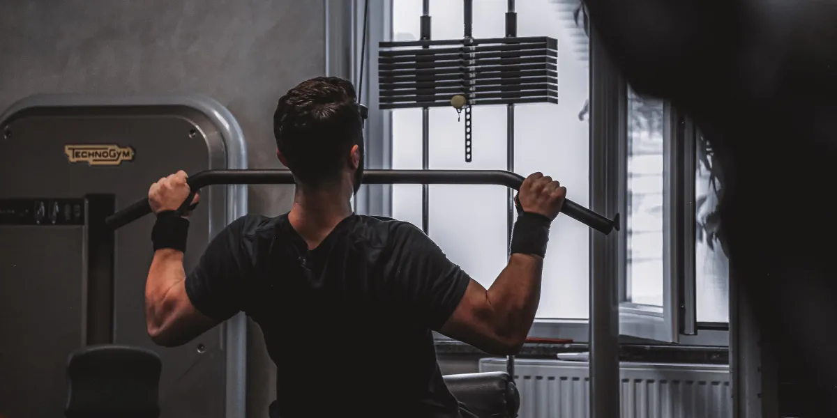 Man doing a lat pulldown on a cable machine in a gym