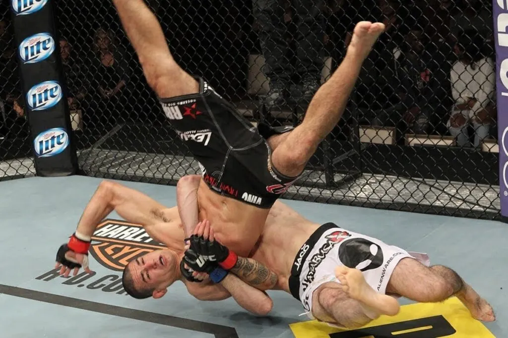 MMA fighter being slammed to the mat by an opponent during a cage bout