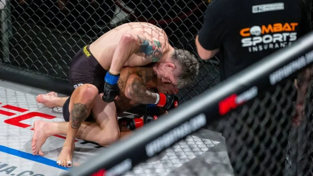 MMA fighters grappling on the canvas beside a Combat Sports Insurance banner on the cage