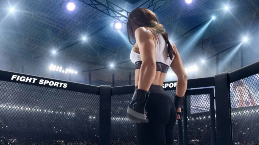 Female fighter in gloves seen from behind, walking into an arena cage