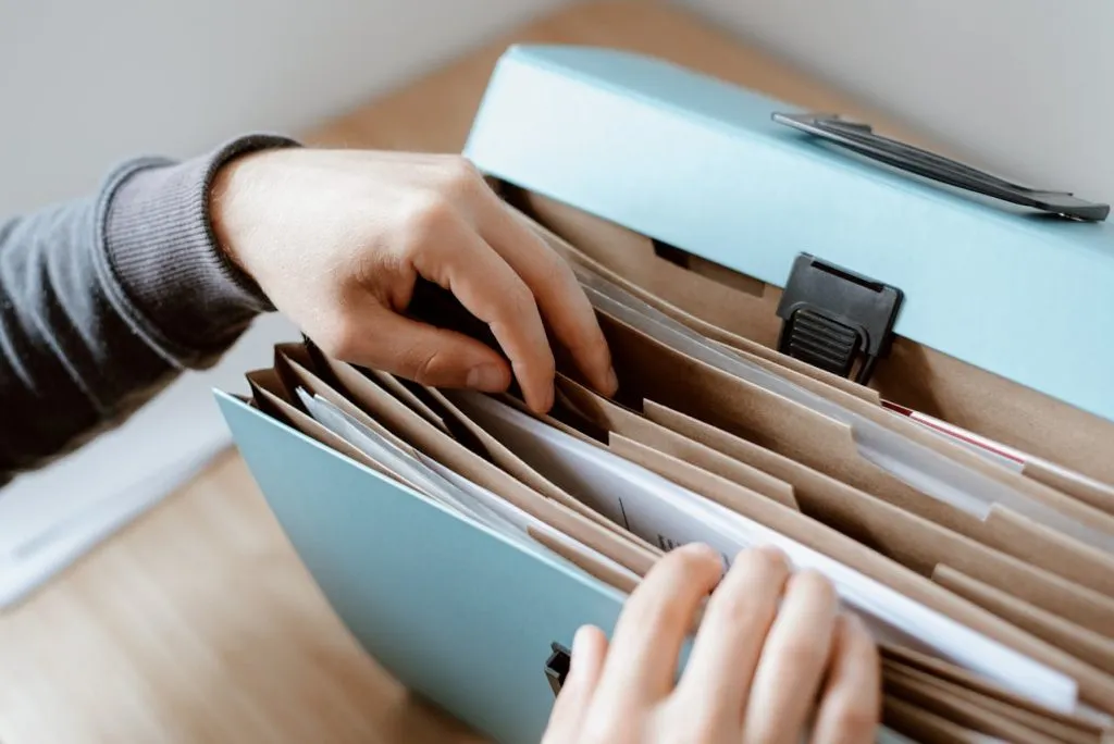 Hand reaching into a box of filed folders