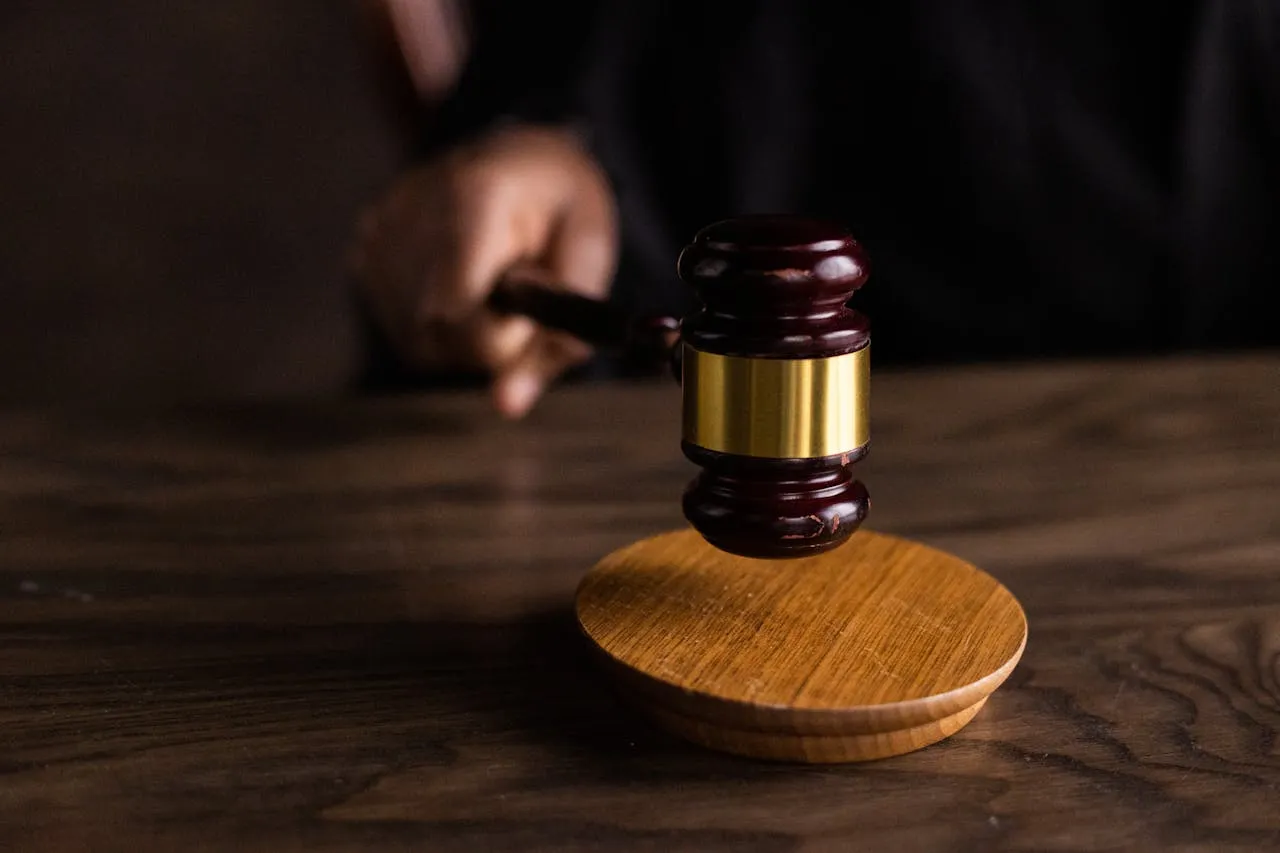 Wooden gavel resting on its block on a dark desk