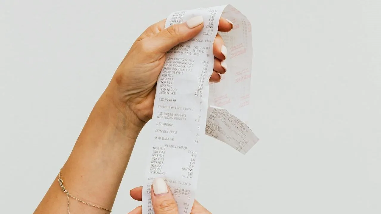 Hand holding a long paper receipt