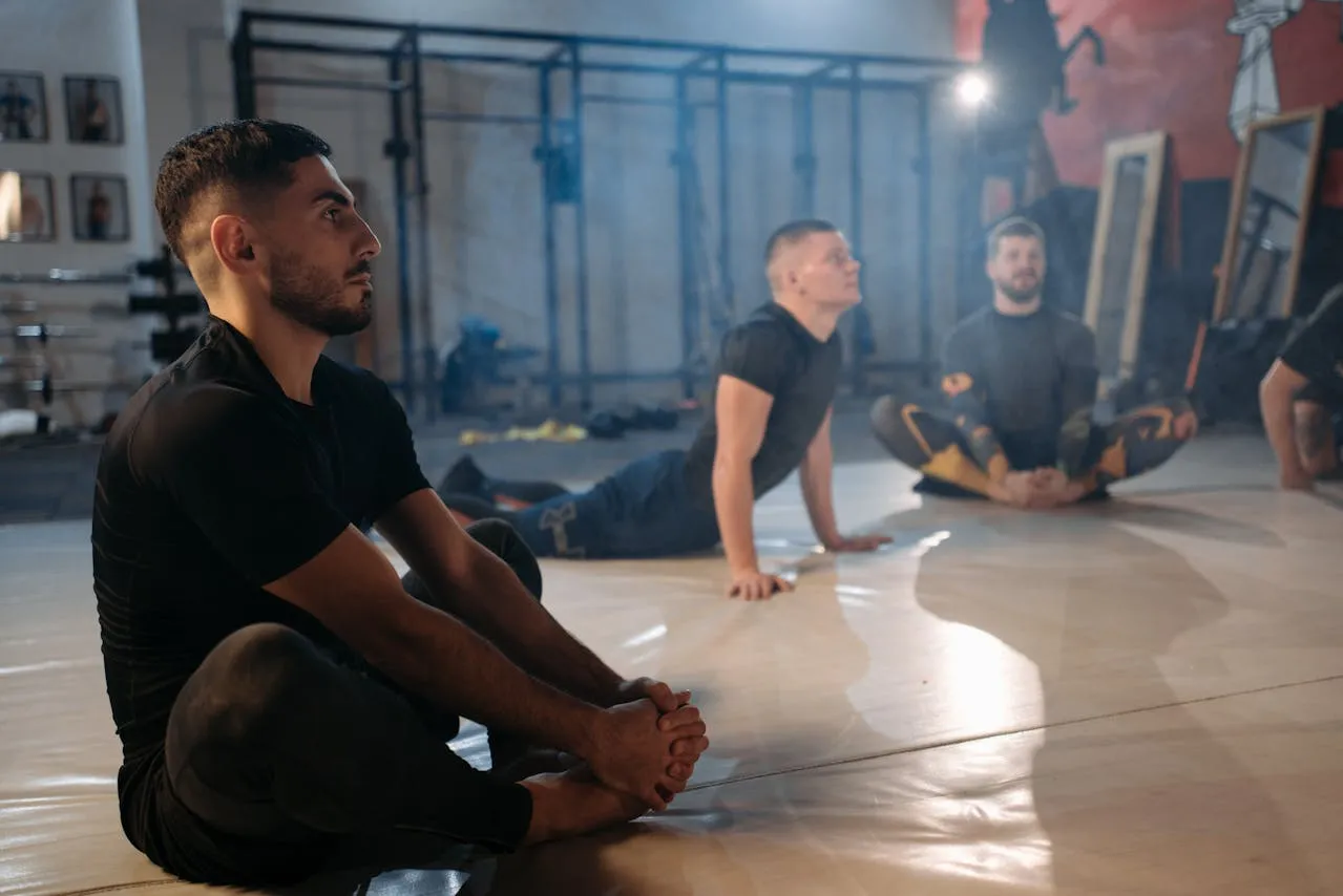 Fighters sitting on the gym floor listening during a group session