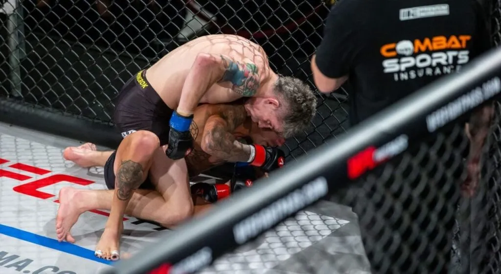 MMA fighters grappling on the canvas beside a Combat Sports Insurance banner on the cage