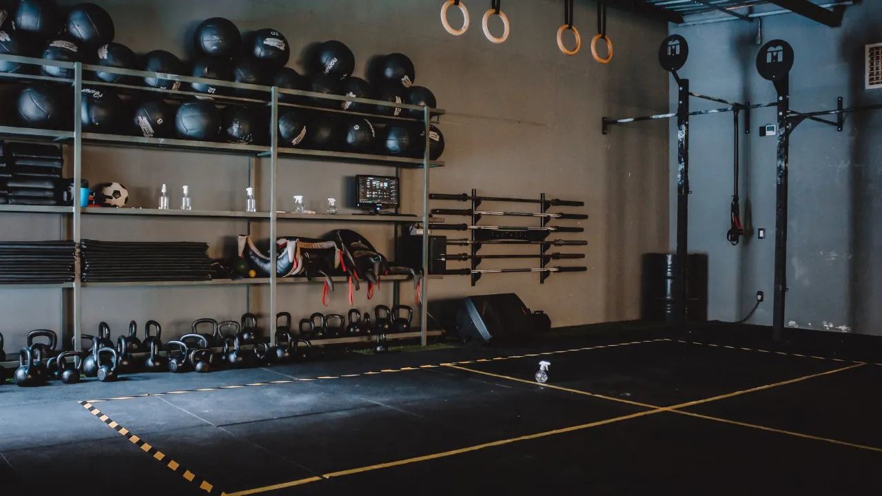 Empty gym with kettlebells, medicine balls and wall-mounted bars and no people