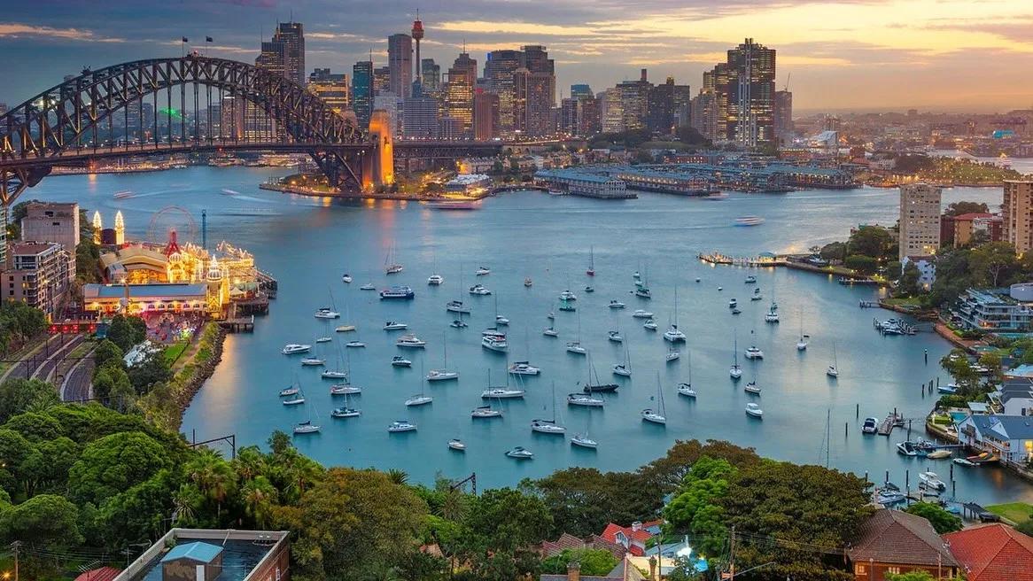 Sydney Harbour at dusk with the Harbour Bridge, Luna Park and moored boats