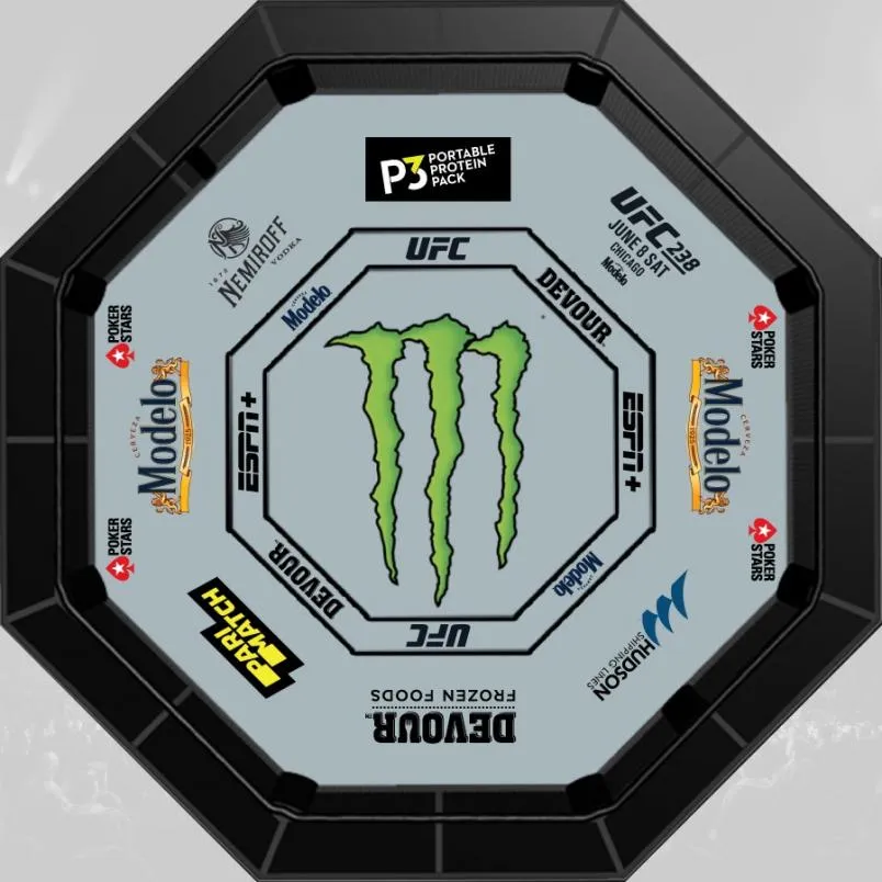 Overhead view of an empty MMA cage floor covered in sponsor logos