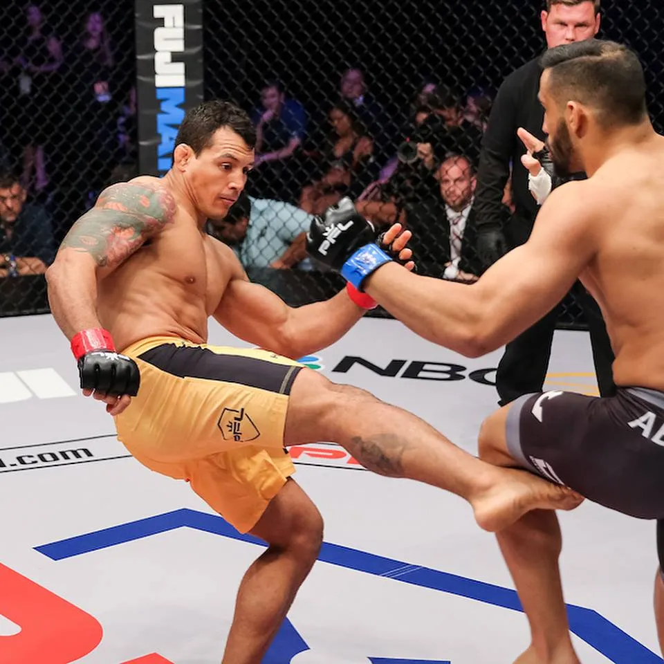 MMA fighter landing a low leg kick on an opponent inside the cage